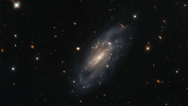 Spiral galaxy UGC 11860 looks serene, but space agencies say it is an explosive whirlpool of disaster. Picture: NASA/ESA