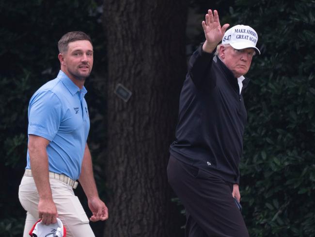 President Donald Trump, right, walks toward the Oval Office as he returns to the White House with Bryson DeChambeau, winner of the 2024 U.S. Open, after playing golf, on Sunday. Picture: AP