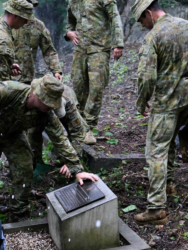 Army and navy personnel clean up the area around the memorial. Picture: Colin Murty