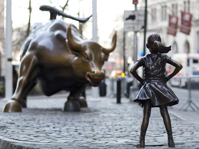 In this March 22, 2017 photo, the Charging Bull and Fearless Girl statues are sit on Lower Broadway in New York. Since 1989 the bronze bull has stood in New York City's financial district as an image of the might and hard-charging spirit of Wall Street. But the installation of the bold girl defiantly standing in the bull's path has transformed the meaning of one of New York's best-known public artworks. Pressure is mounting on the city to let the Fearless Girl stay. (AP Photo/Mark Lennihan)