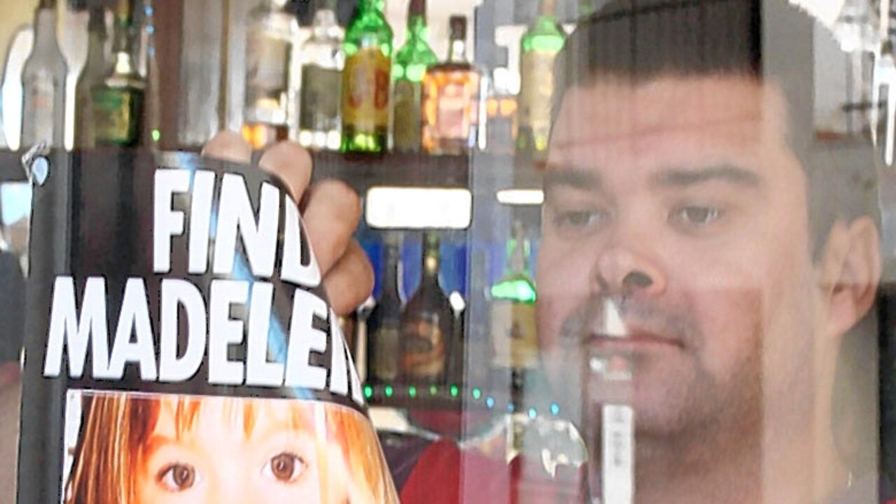 A worker at Cafe Polly removing poster showing missing British tourist child Madeleine McCann in Praia da Luz, Portugal.