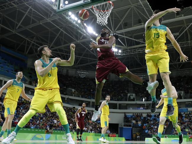 Venezuela's Miguel Ruiz, center, drives to the basket between Australia's Andrew Bogut (6) and Damian Martin (15) during a basketball game at the 2016 Summer Olympics in Rio de Janeiro, Brazil, Sunday, Aug. 14, 2016. (AP Photo/Charlie Neibergall)