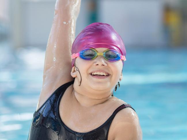 young and successful swimmers pose in swimming pool