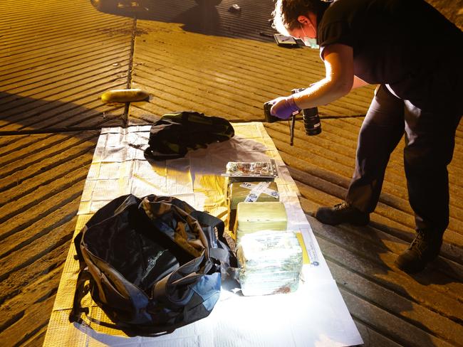 Police inspect drugs seized during the raid. Picture: Police Media