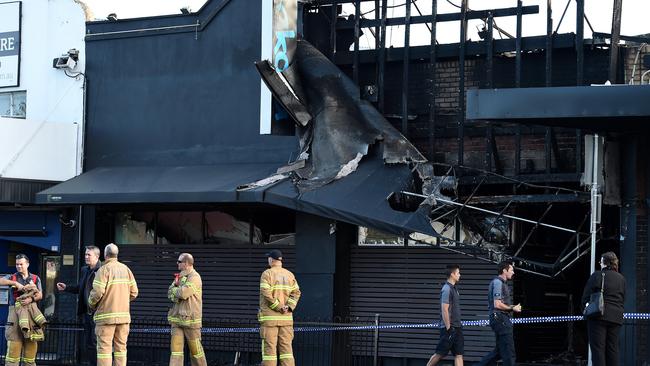 Fire investigators examine the scene this morning. Picture: Steve Tanner