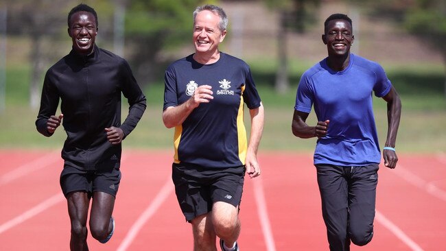 Joseph Deng, left, Bill Shorten and Peter Bol hit the track.