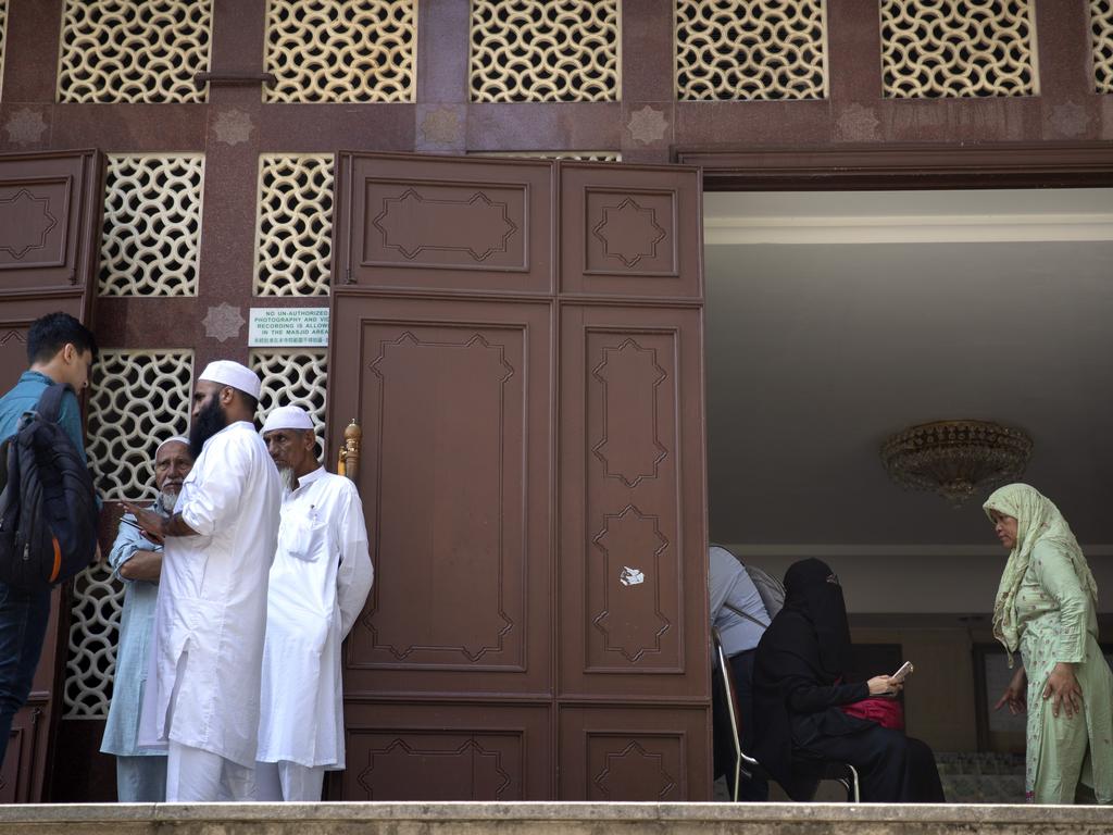 People stand at the entrance to the Kowloon Mosque a day after it was sprayed with blue-dyed water by a police riot-control vehicle in Hong Kong. Picture: AP Photo