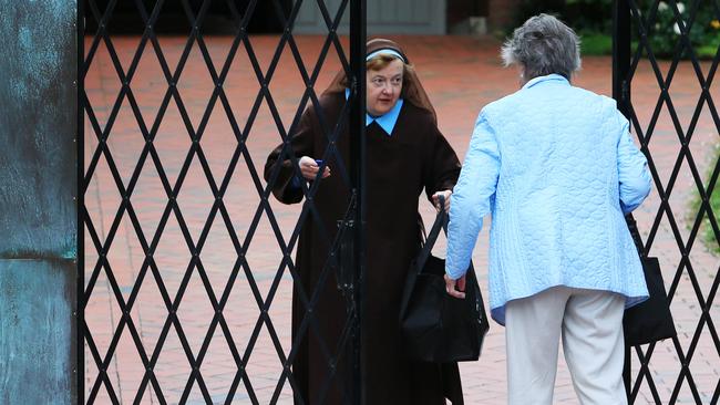 A nun opens the gates for a visitor to the Carmelite Monastery in Kew. Picture: Aaron Francis