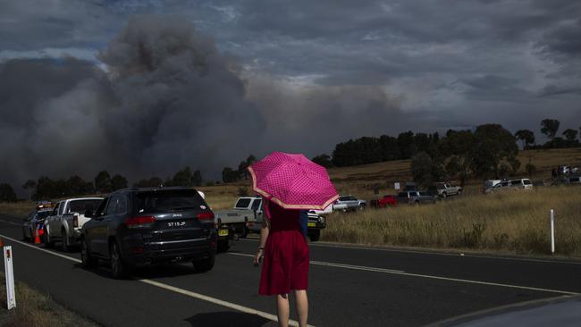 Genevieve Devin watches plumes of smoke as a fire approaches Hoskinstown. Picture: Sean Davey