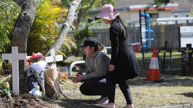 People lay tributes at the base of a tree at the scene in Ashcroft on Tuesday morning. Picture: Rohan Kelly