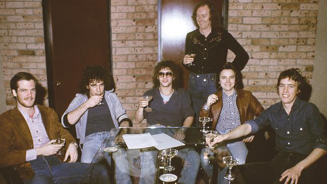 Former Cold Chisel manager Rod Willis, standing, after the band had signed a record deal with Warner Music in September 1977. Picture: Phil Mortlock