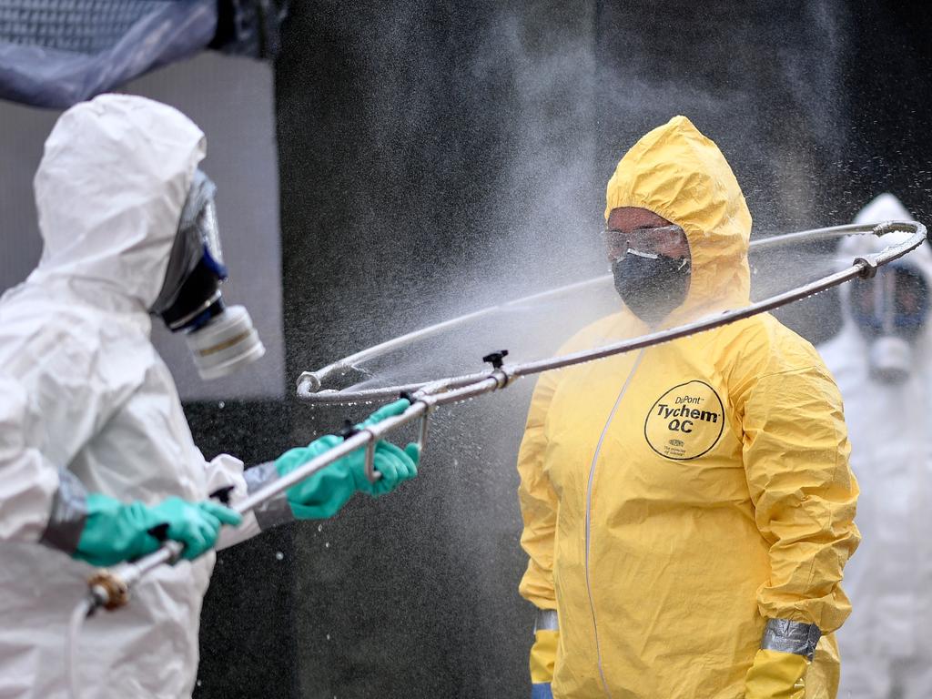 Brazil's military, firefighters and Civil Defense members disinfect each other after cleaning a bus station in Belo Horizonte, Brazil. Picture: DOUGLAS MAGNO / AFP