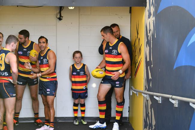 Crows co-captain Taylor Walker talks with a lucky young Adelaide supporter in the race before the players run onto Adelaide Oval to play the Fremantle Dockers. Picture: David Mariuz/AAP