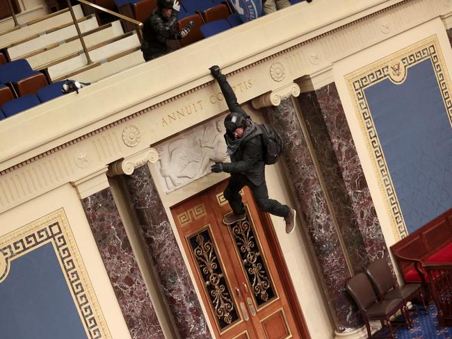 A protester is seen hanging from the balcony in the Senate Chamber. Picture: Getty