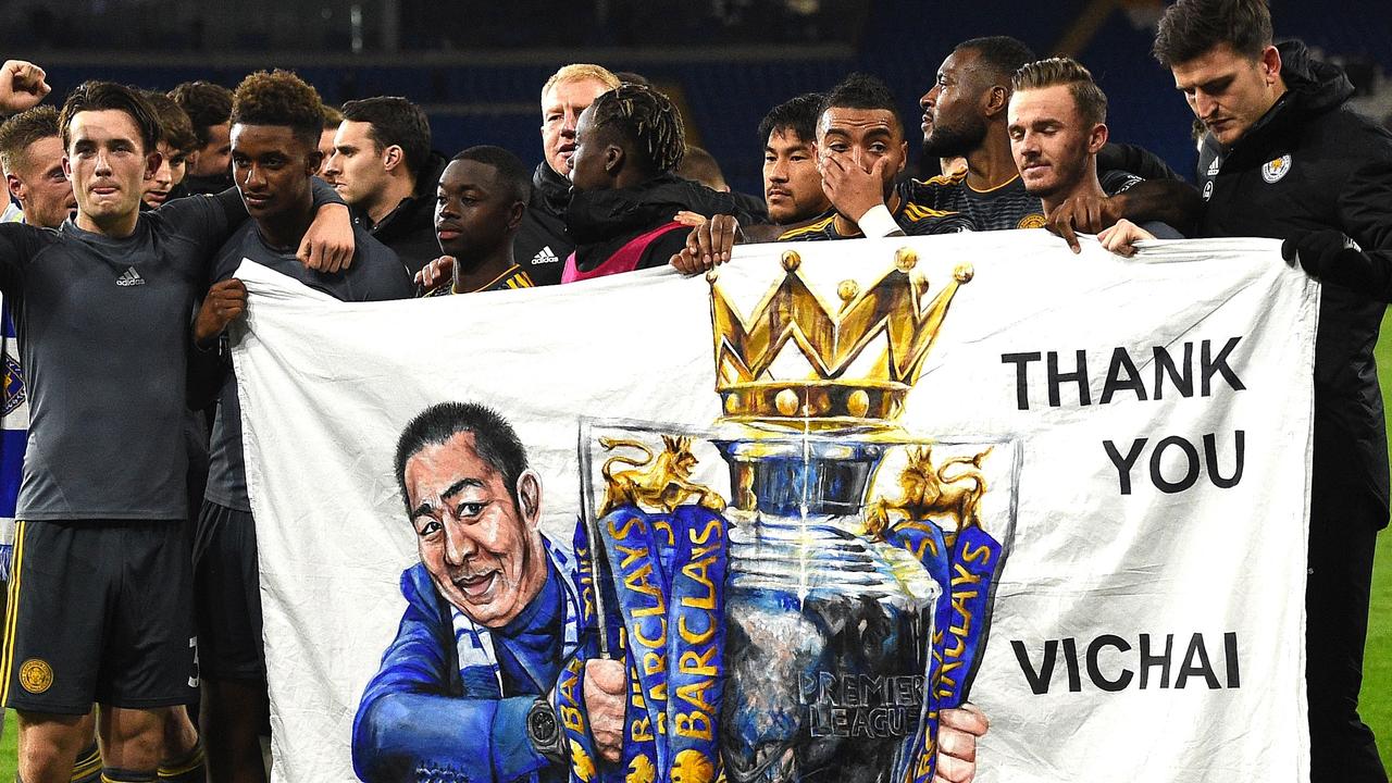 Leicester City' players hold a banner showing late Chairman Vichai Srivaddhanaprabha holding the Premier League Cup