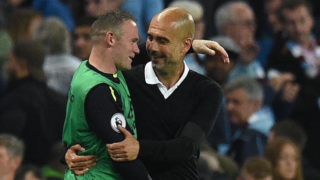 Manchester City's Spanish manager Pep Guardiola (R) and Everton's English striker Wayne Rooney.