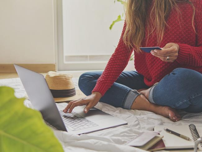 Beautiful young female traveler shopping online or in flight. with credit card at home, top view. Concept creative work at home. Selective focus.Doc Holiday Oct 9Pic istock