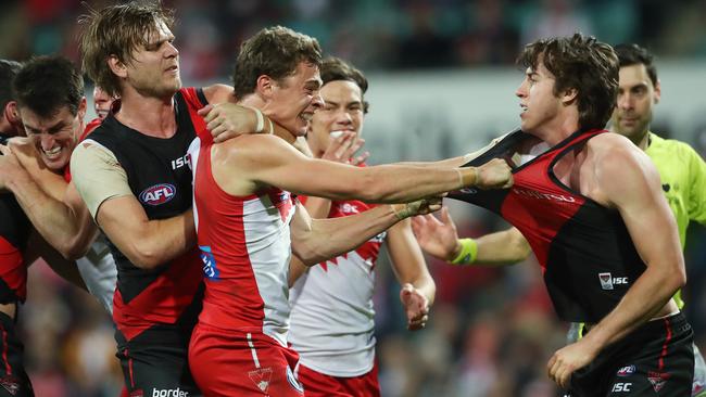 Sydney's Will Hayward receives rough play from Essendon's Michael Hurley and Andrew McGrath.