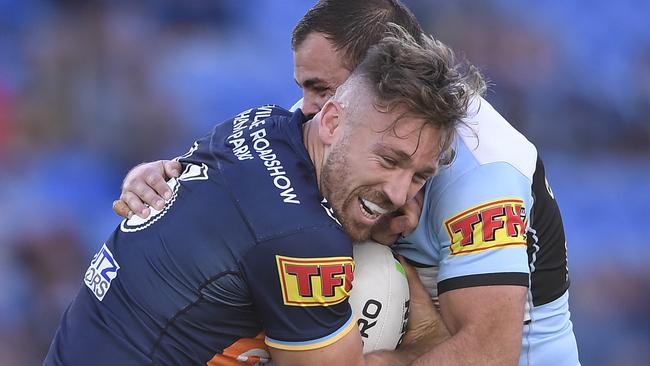 GOLD COAST, AUSTRALIA - JULY 04: Bryce Cartwright of the Titans is tackled by Wade Graham of the Sharks during the round eight NRL match between the Gold Coast Titans and the Cronulla Sharks at Cbus Super Stadium on July 04, 2020 in Gold Coast, Australia. (Photo by Ian Hitchcock/Getty Images)