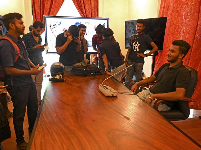 An unidentified man poses for pictures while seated on President Gotabaya Rajapaksa’s chair at the presidential palace in Colombo. Picture: AFP