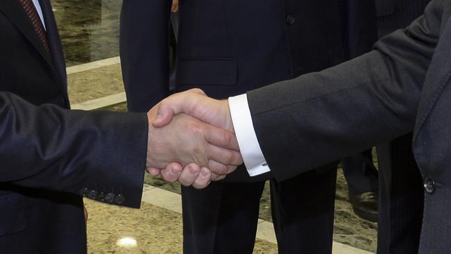 Russian President Vladimir Putin, left, shakes hands with Ukrainian President Petro Poroshenko, right, prior their talks in Minsk, Belarus. Picture: Sergei Bondarenko