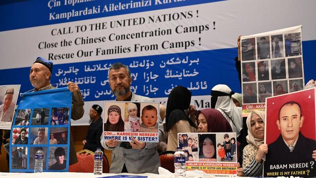 Members of the Uighur community present pictures of their relatives detained in China during a press conference in Istanbul. Picture: AFP