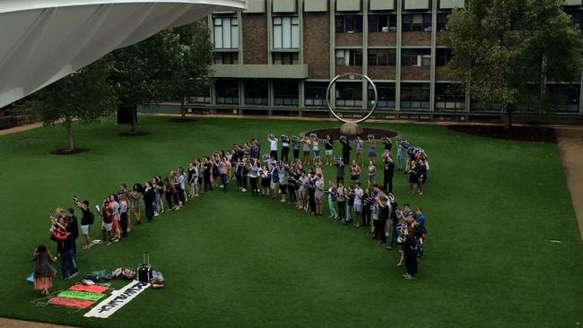 Students gather and form an ‘R’ for ‘respect’ at a demonstration on the lawns of UNSW after footage of college boys chanting sexist and vulgar songs was leaked.