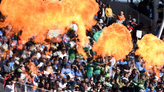 Pakistan cricket fans set off pyrotechnics as they celebrate a boundary during the ICC Champions trophy match between India and Pakistan at Edgbaston in Birmingham on June 4, 2017. / AFP PHOTO / OLI SCARFF / RESTRICTED TO EDITORIAL USE