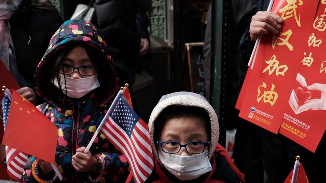 Children wear surgical masks to protect themselves while watching the annual Lunar New Year Parade in Manhattan's Chinatown, New York. Picture: AFP