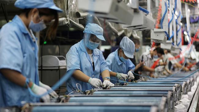 Employees work on an air conditioner production line in Wuhan. Picture: AFP