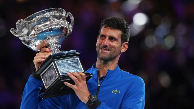 Novak Djokovic lifts the trophy after his clinical defeat of Rafael Nadal in the Australian Open final in Melbourne last night. Picture: Getty Images 