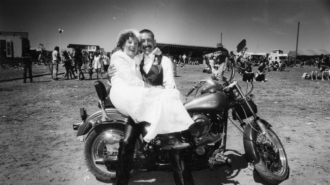 Newlyweds Ben van Hassel and Lorry Brooks sitting on Harley Davidson motorcycle after their wedding at the Ponde 94 rock festival.