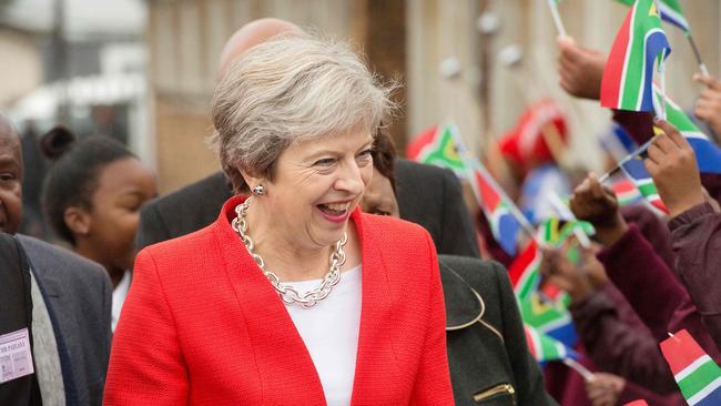 Theresa May is greeted by schoolchildren waving British and South African flags, during a visit to the ID Mkhize Secondary School in Gugulethu township. Picture: Rodger Bosch / AFP