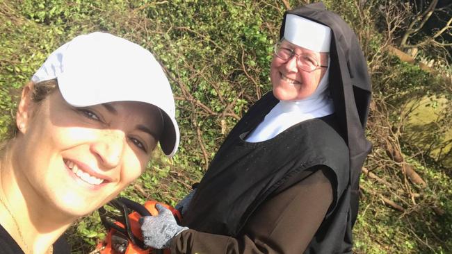 The nun showed everyone how to clear up a fallen tree.