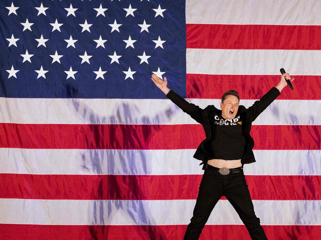 Elon Musk jumps on stage at a town hall event during Donald Trump’s election campaign. Picture: AFP