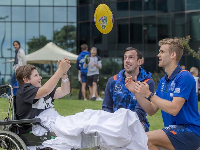 North Melbourne players Todd Goldstein and Ed Vickers-Willis visit Braedyn Melone, 11. Picture: Jason Edwards