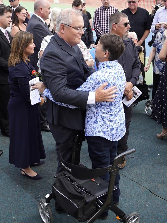 Prime Minister Scott Morrison embraces Christine McPaul during the funeral for her volunteer firefighter son Samuel McPaul at Holbrook Sports Stadium yesterday. Picture: Getty Images