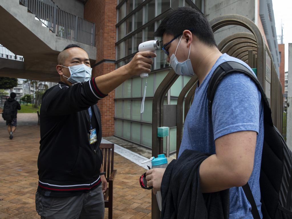 Taiwanese students get their temperature checked as they enter the Taipei American school last month in Taipei, Taiwan. Taiwan, Singapore and Hong Kong have had more successful approaches in battling the pandemic. Picture: Paula Bronstein