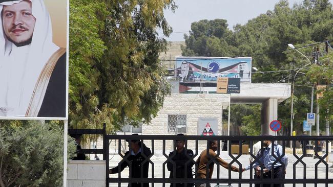 A portrait of Jordan's King Abdullah II (L) is seen next to the closed gate of the Ramtha border crossing between Jordan and Syria. Picture: AFP.