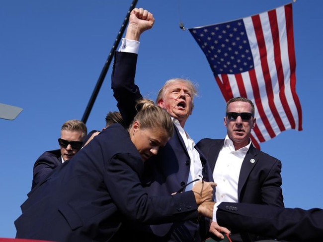 Republican presidential candidate Donald Trump is surrounded by U.S. Secret Service agents at a campaign rally in Butler, Pa, as he uttered his 'Fight Fight Fight!' catchphrase. (AP Photo/Evan Vucci)