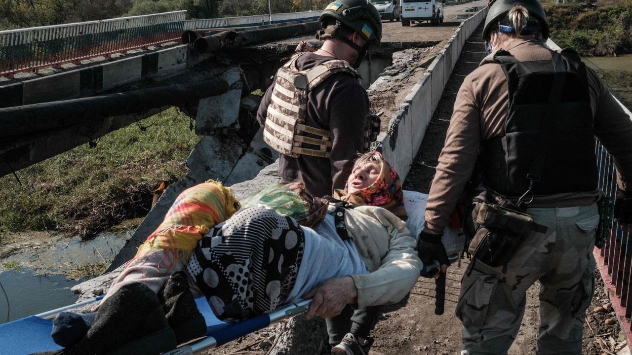 Dusya, 86, is carried on a stretcher by volunteers in Kupiansk, Kharkiv region, where 20 civilians were reportedly killed. Picture: Yasuyoshi Chiba / AFP