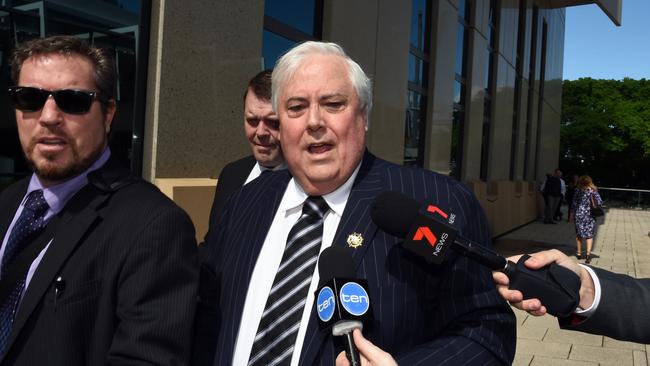 Clive Palmer, flanked by security guards, arrives at the Federal Court yesterday.