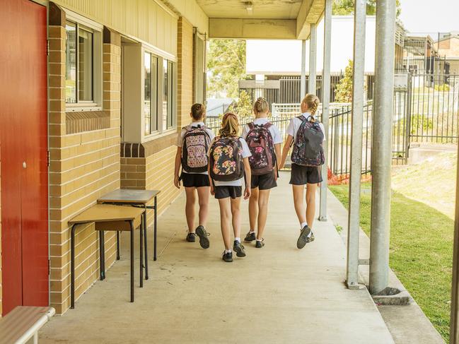 Group of junior high school girl students walking through school