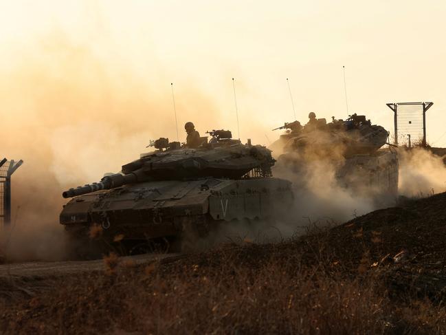 Israeli tanks move in an undisclosed location along the border with the Gaza Strip on October 18, 2023. Thousands of people, both Israeli and Palestinians have died since October 7, 2023, when Palestinian Hamas militants in the Gaza Strip entered southern Israel in a surprise attack leading Israel to declare war on Hamas in Gaza on October 8. (Photo by GIL COHEN MAGEN / AFP)