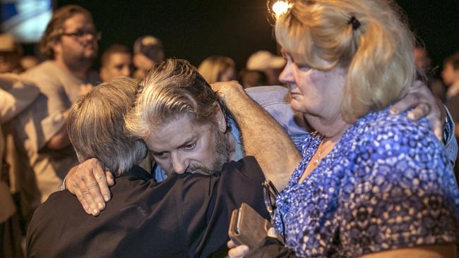 Texas Gov. Greg Abbott consoles Ted and Ann Montgomery, members of the First Baptist Church. Picture: AP