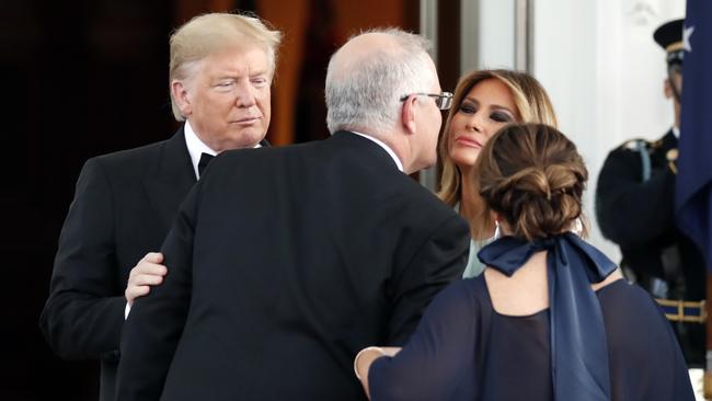 Mr Morrison greets the First Lady with a kiss.