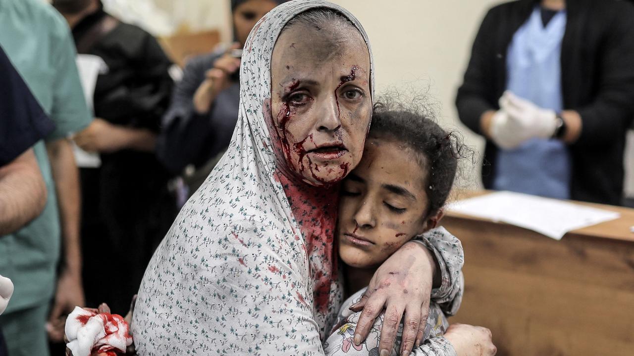 An injured Palestinian woman covered in dust and blood hugs an injured girl after the Israeli bombardment of Khan Yunis in the southern Gaza Strip on November 15, 2023. Picture: Belal Khaled/AFP