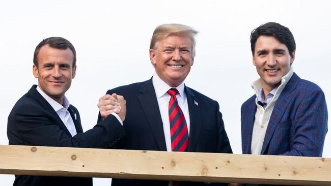 Canadian Prime Minister Justin Trudeau and French President Emmanuel Macron smiling on a balcony.