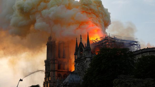 A firefighter uses a hose to douse flames and smoke billowing from the roof at Notre-Dame Cathedral on April 15, 2019. Picture: Geoffroy Van Der Hasselt/AFP