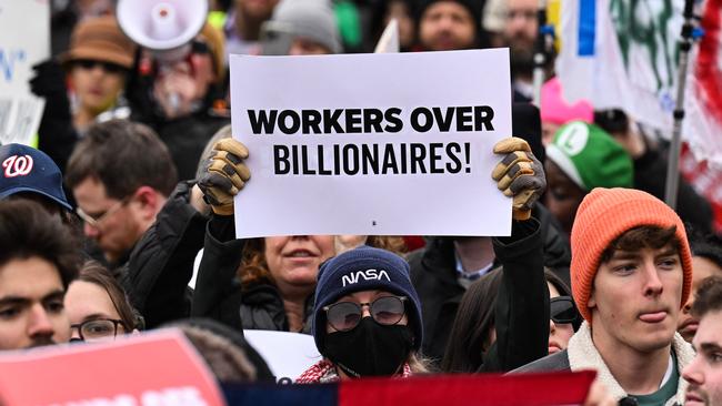 A person holds up a sign as they protest against the Department of Government Efficiency (DOGE) outside of the US Department of Labor in Washington. Picture: AFP